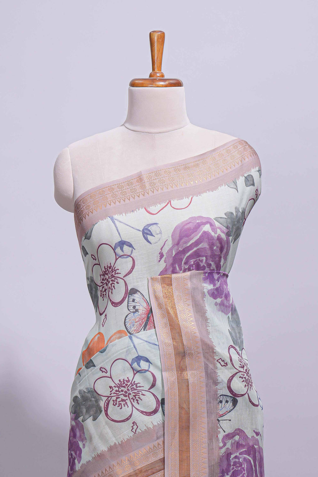 Ivory colour linen saree floral prints with pastel accents by a subtle gold zari border and printed pallu with tassel along with printed blouse