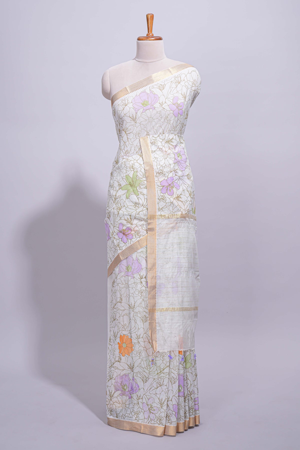 White linen saree delicate floral prints with pastel accents by a subtle gold zari border and  striped pallu with tassel  along with self blouse
