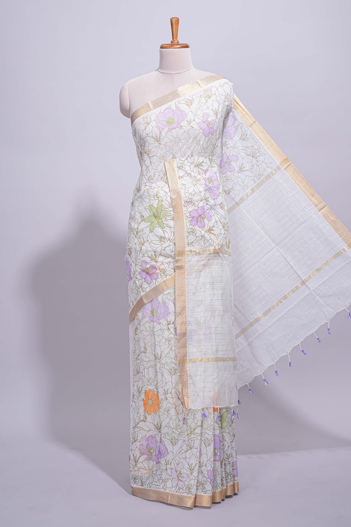 White linen saree delicate floral prints with pastel accents by a subtle gold zari border and  striped pallu with tassel  along with self blouse
