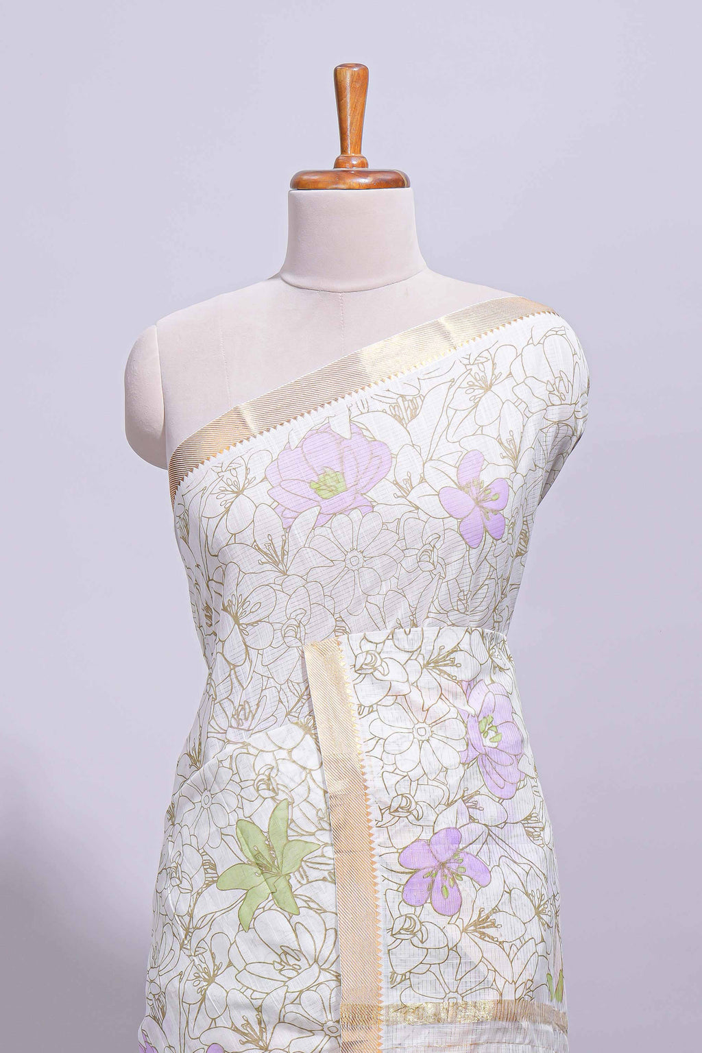 White linen saree delicate floral prints with pastel accents by a subtle gold zari border and  striped pallu with tassel  along with self blouse
