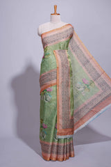 Soft green linen saree with floral print highlighted with afloral pallu and zari border along with contrast blouse piece