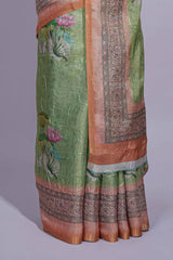 Soft green linen saree with floral print highlighted with afloral pallu and zari border along with contrast blouse piece