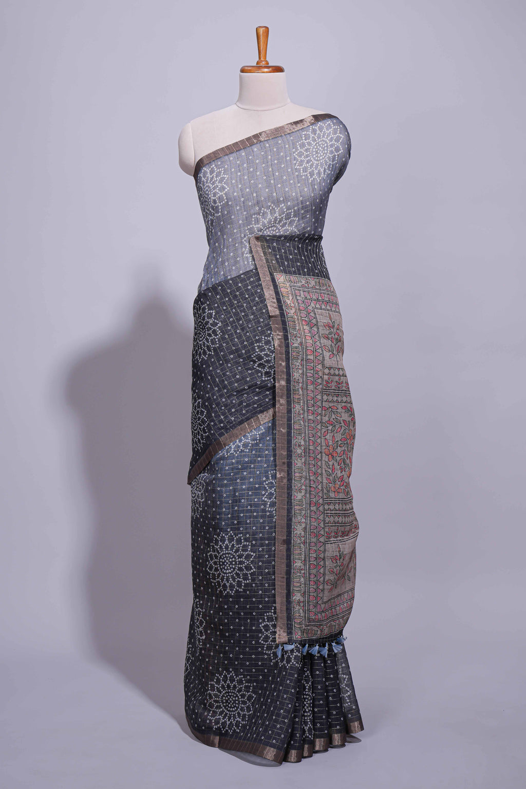 Elegant black and charcoal linen saree with geometric dotted motifs paired with a floral printed pallu and contrast border with tassel along with printed blouse