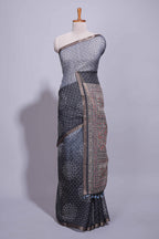 Elegant black and charcoal linen saree with geometric dotted motifs paired with a floral printed pallu and contrast border with tassel along with printed blouse