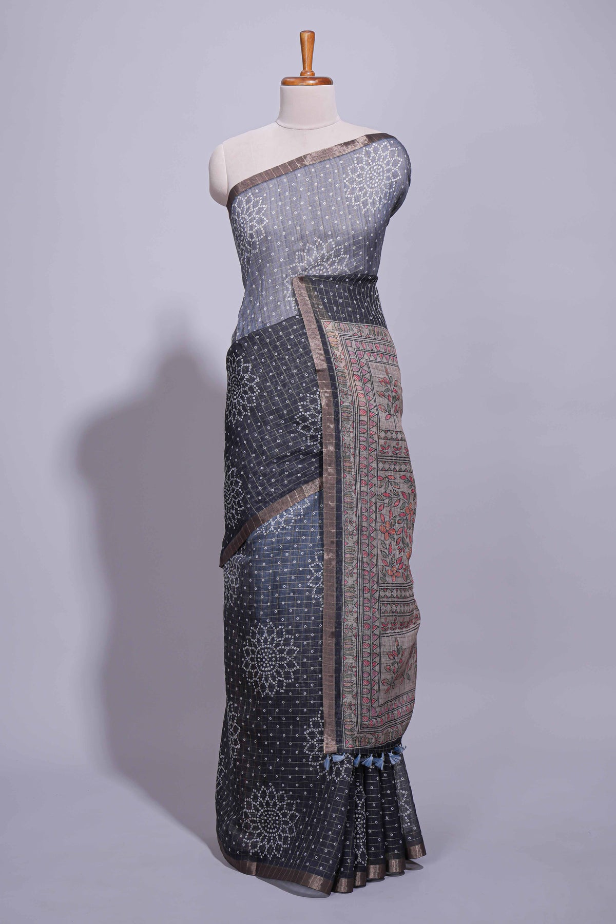 Elegant black and charcoal linen saree with geometric dotted motifs paired with a floral printed pallu and contrast border with tassel along with printed blouse