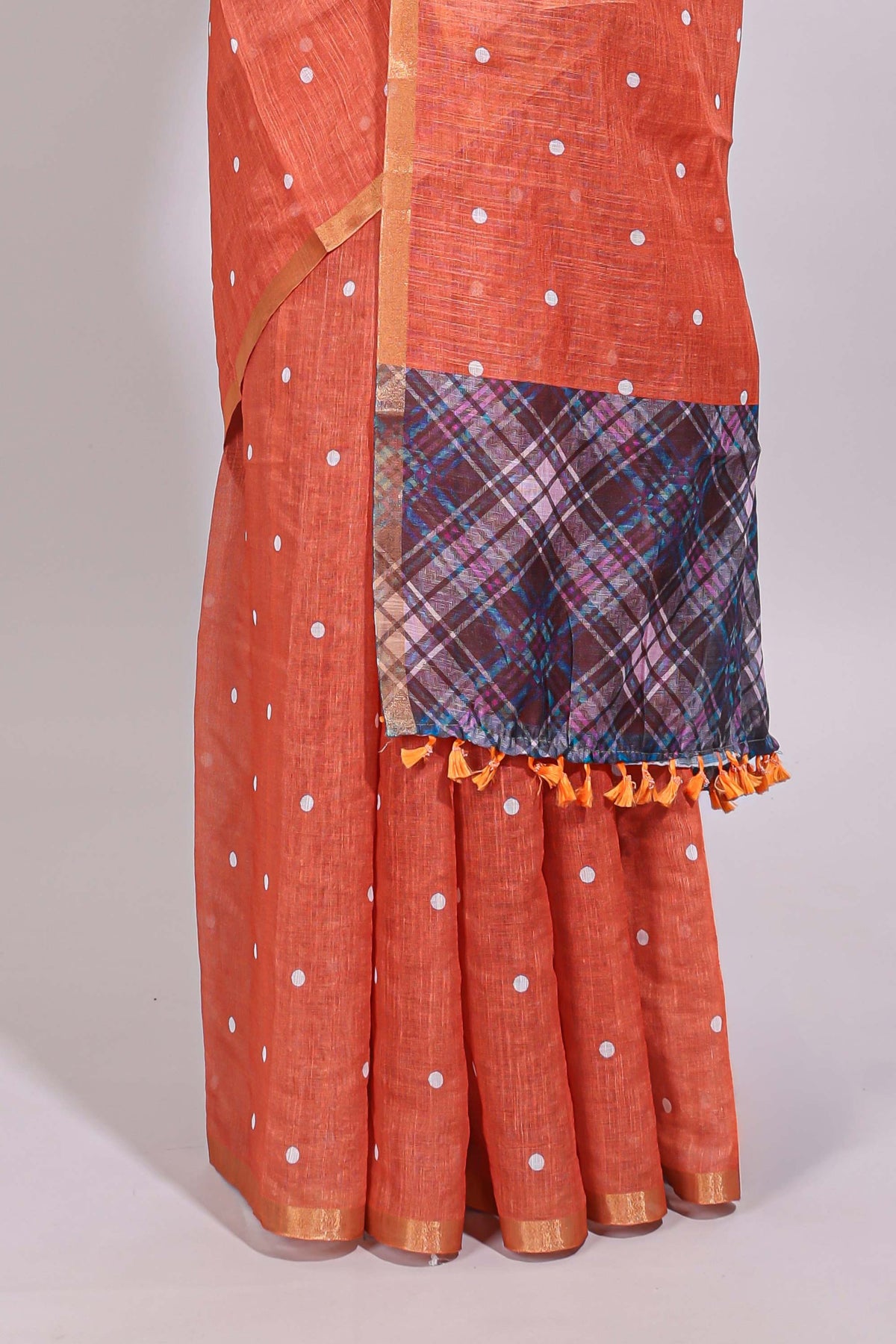 Orange round motifs linen saree with self zari border and contrast checked blouse