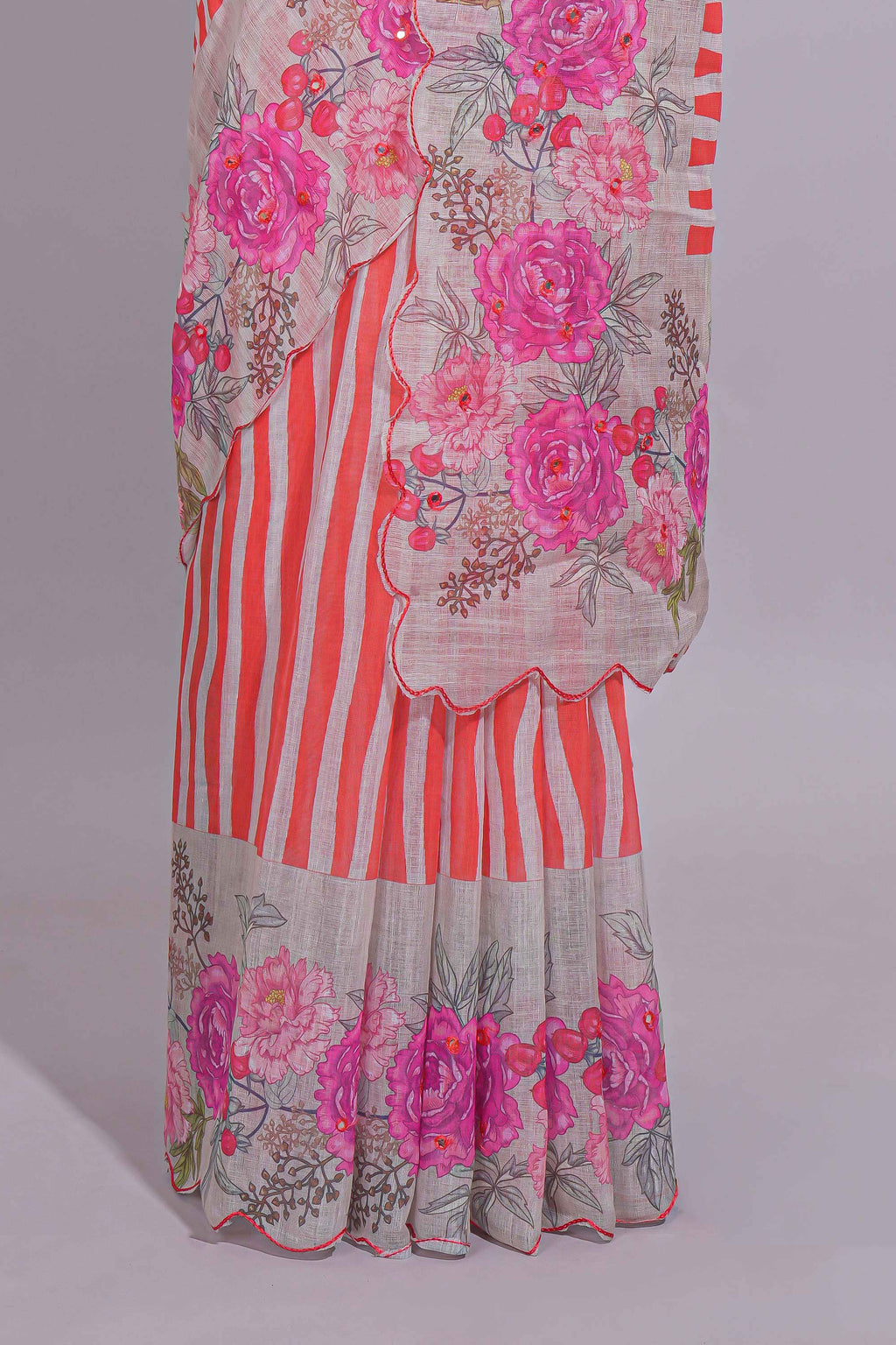 White Linen saree with orange stripes and vibrant pink floral scallop border with contrast printed blouse