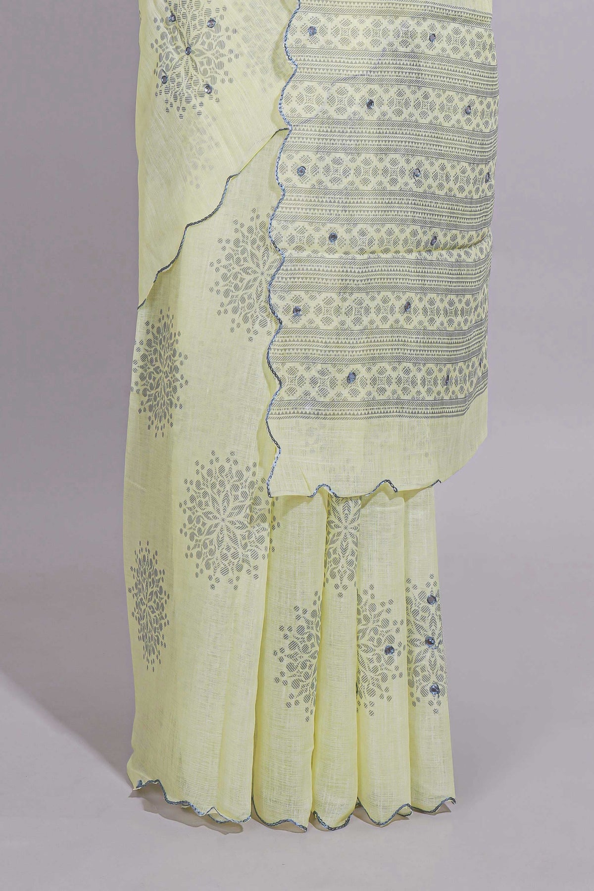 Pastel yellow linen saree tree motifs and tiny sequin with scalloped border and matching blouse
