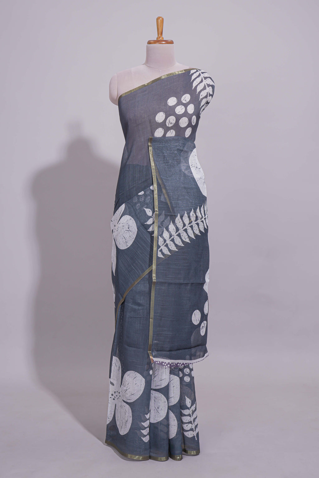 Charcoal grey linen saree with bold white floral and geometric prints finished with a subtle metallic border along with matching blouse