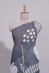 Charcoal grey linen saree with bold white floral and geometric prints finished with a subtle metallic border along with matching blouse