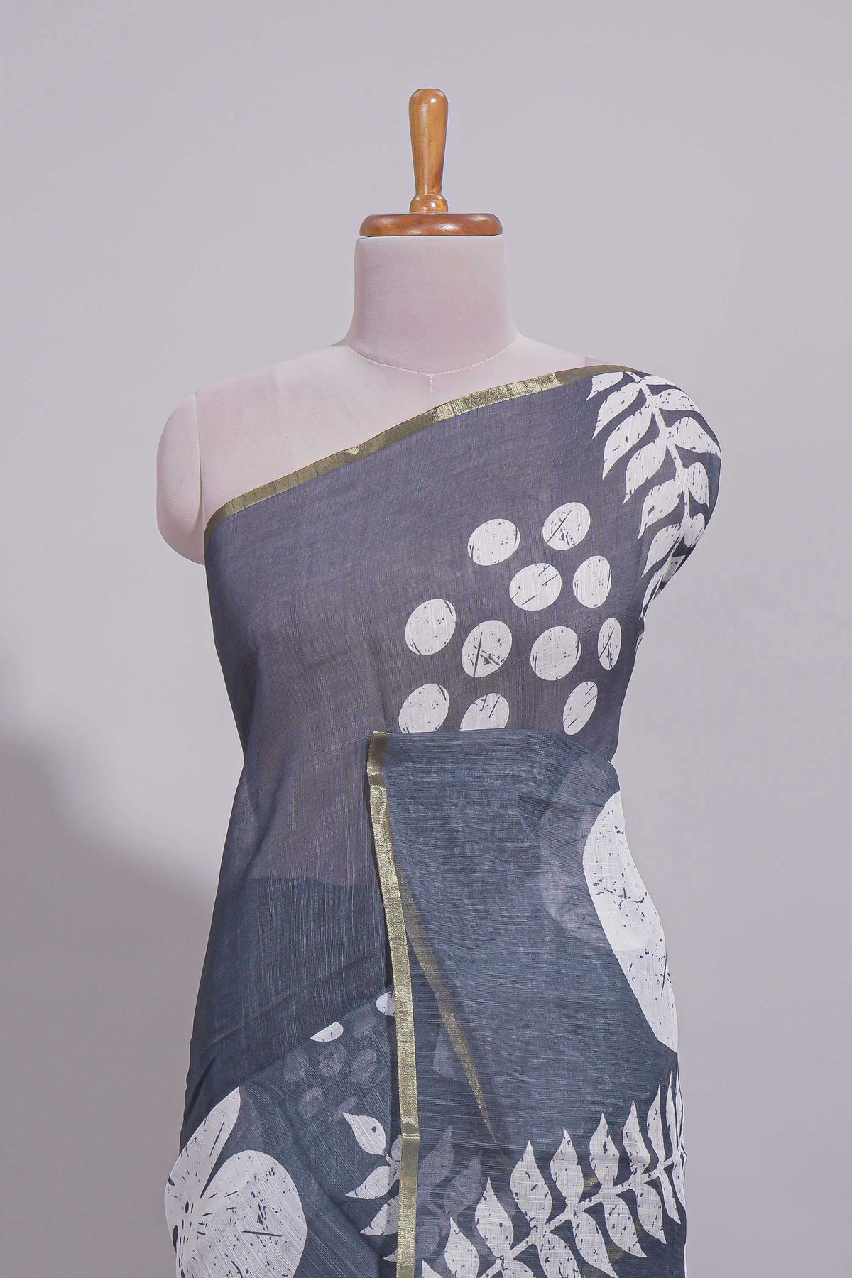 Charcoal grey linen saree with bold white floral and geometric prints finished with a subtle metallic border along with matching blouse