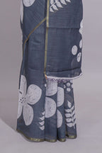 Charcoal grey linen saree with bold white floral and geometric prints finished with a subtle metallic border along with matching blouse