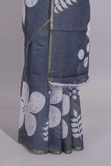 Charcoal grey linen saree with bold white floral and geometric prints finished with a subtle metallic border along with matching blouse