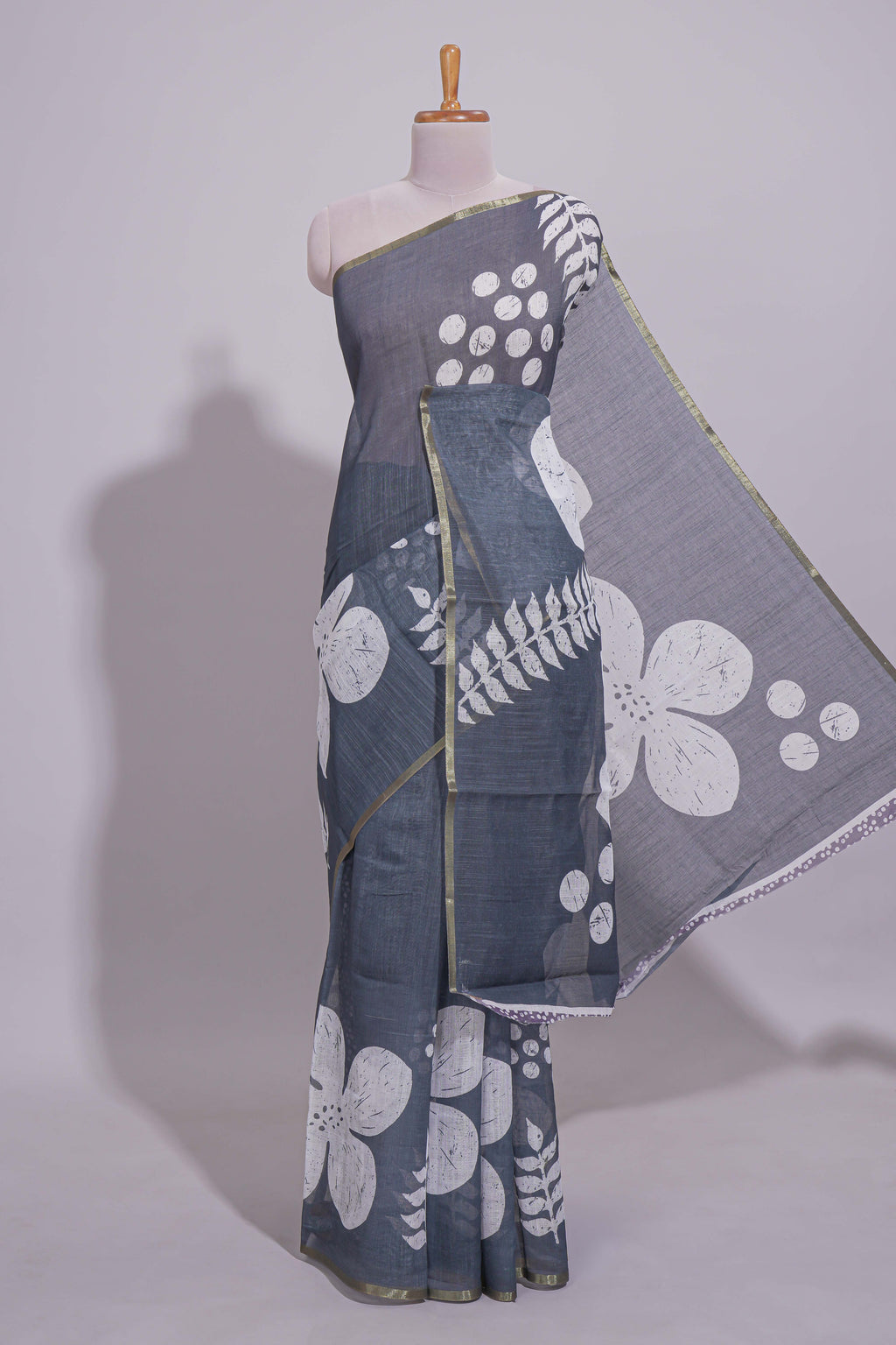 Charcoal grey linen saree with bold white floral and geometric prints finished with a subtle metallic border along with matching blouse