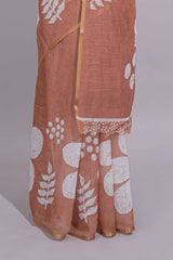 Brown linen saree with bold white floral and geometric prints finished with a subtle metallic border along with matching blouse