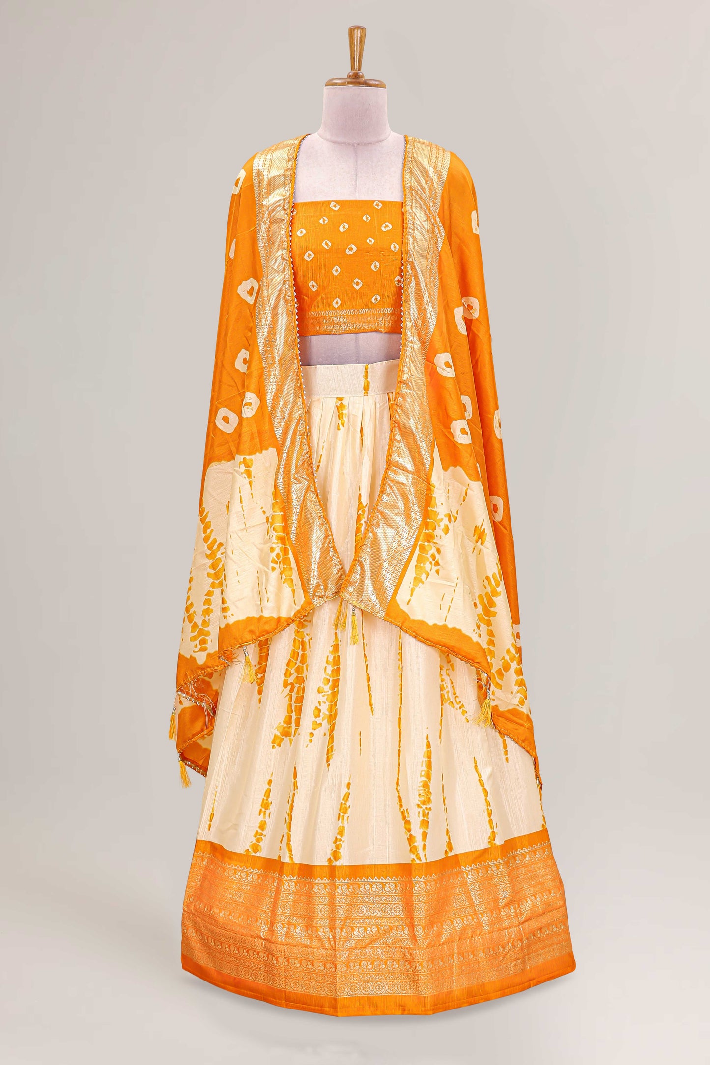 Cream dola silk bandhani designer lehenga with contrast blouse and dhavani