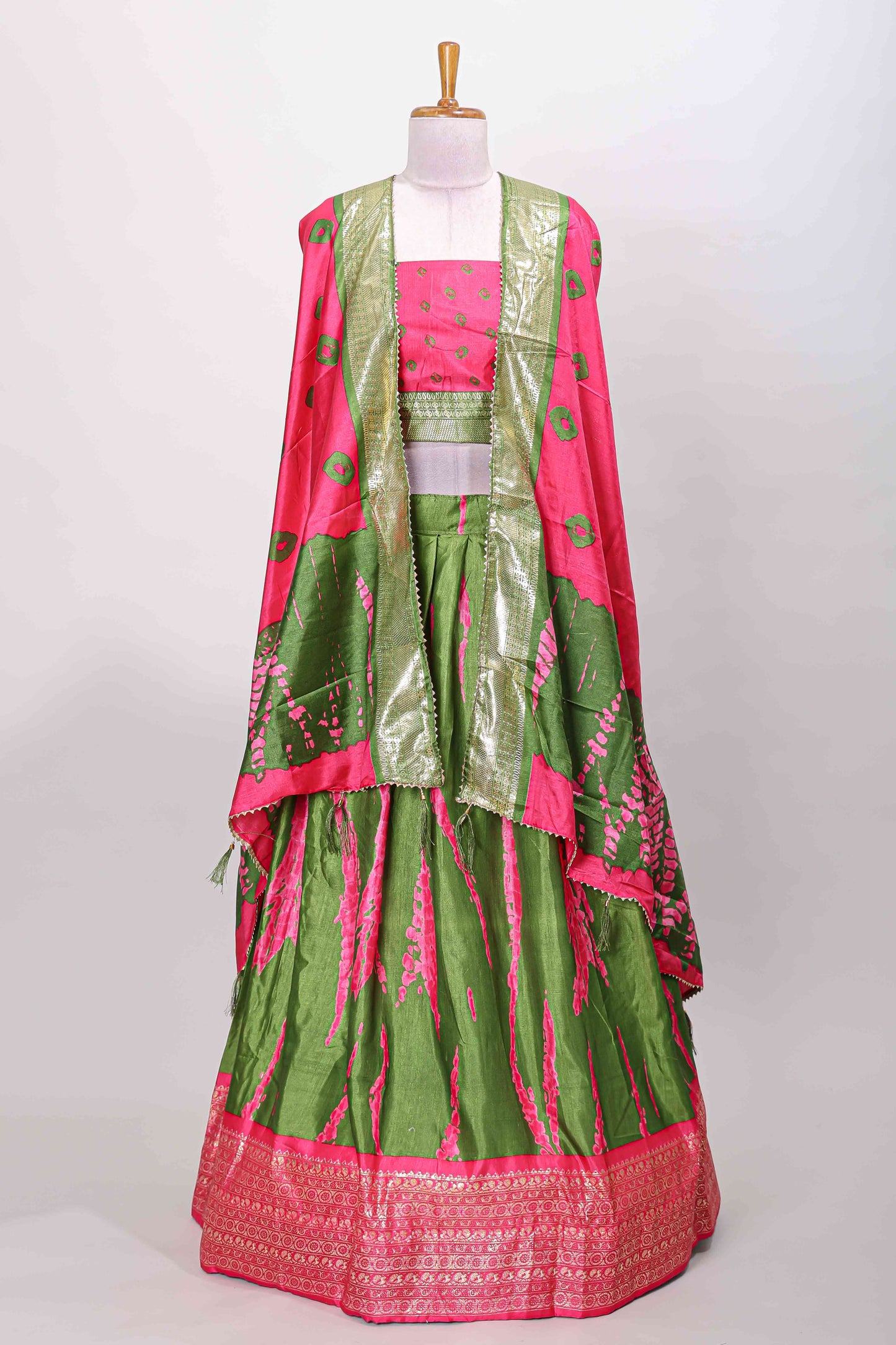 Green dola silk bandhani designer lehenga with contrast blouse and dhavani