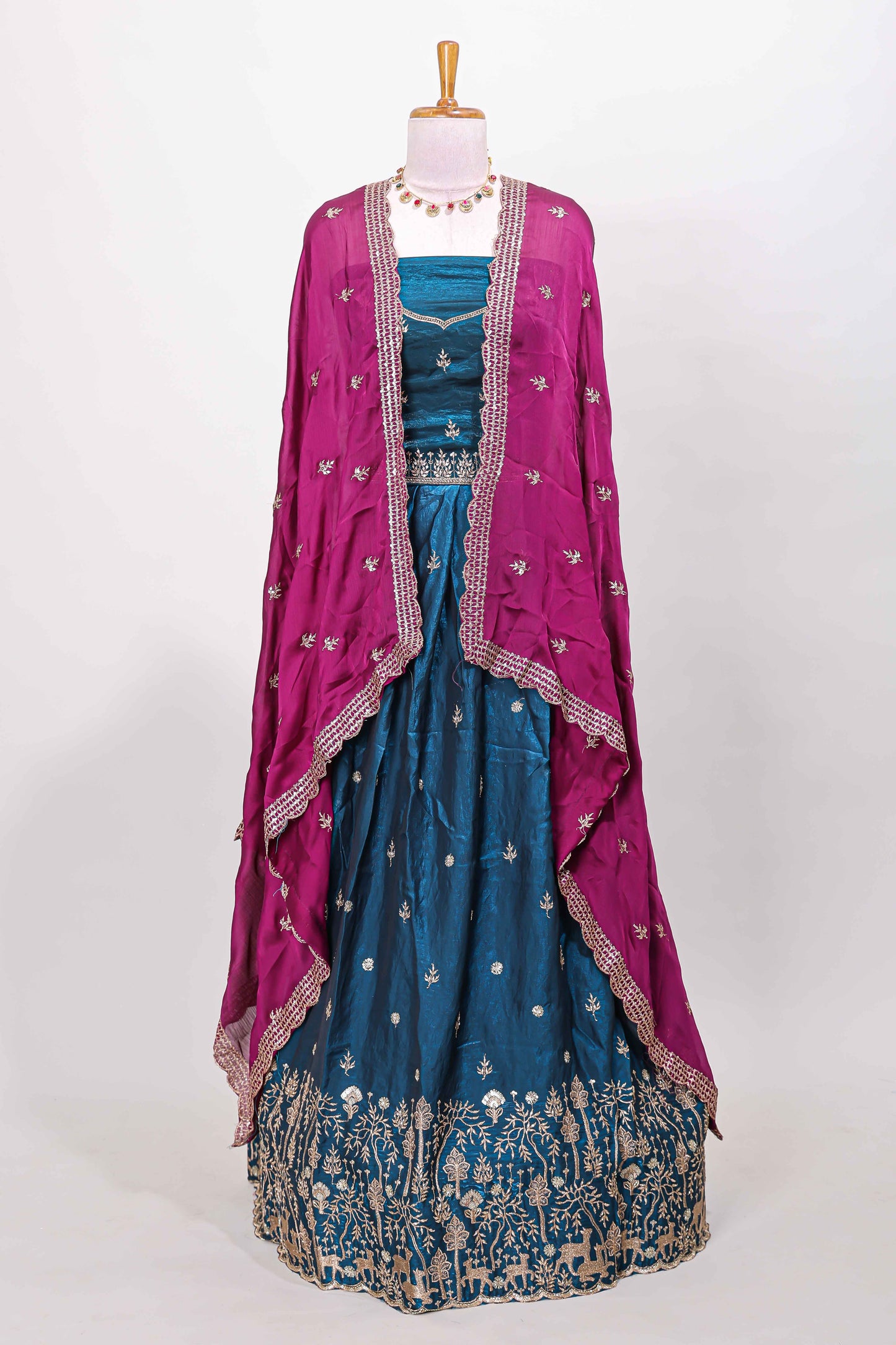 Peacock blue fendy chiffon lehenga with all over embroidery and stone work, paired with a contrast dhavani