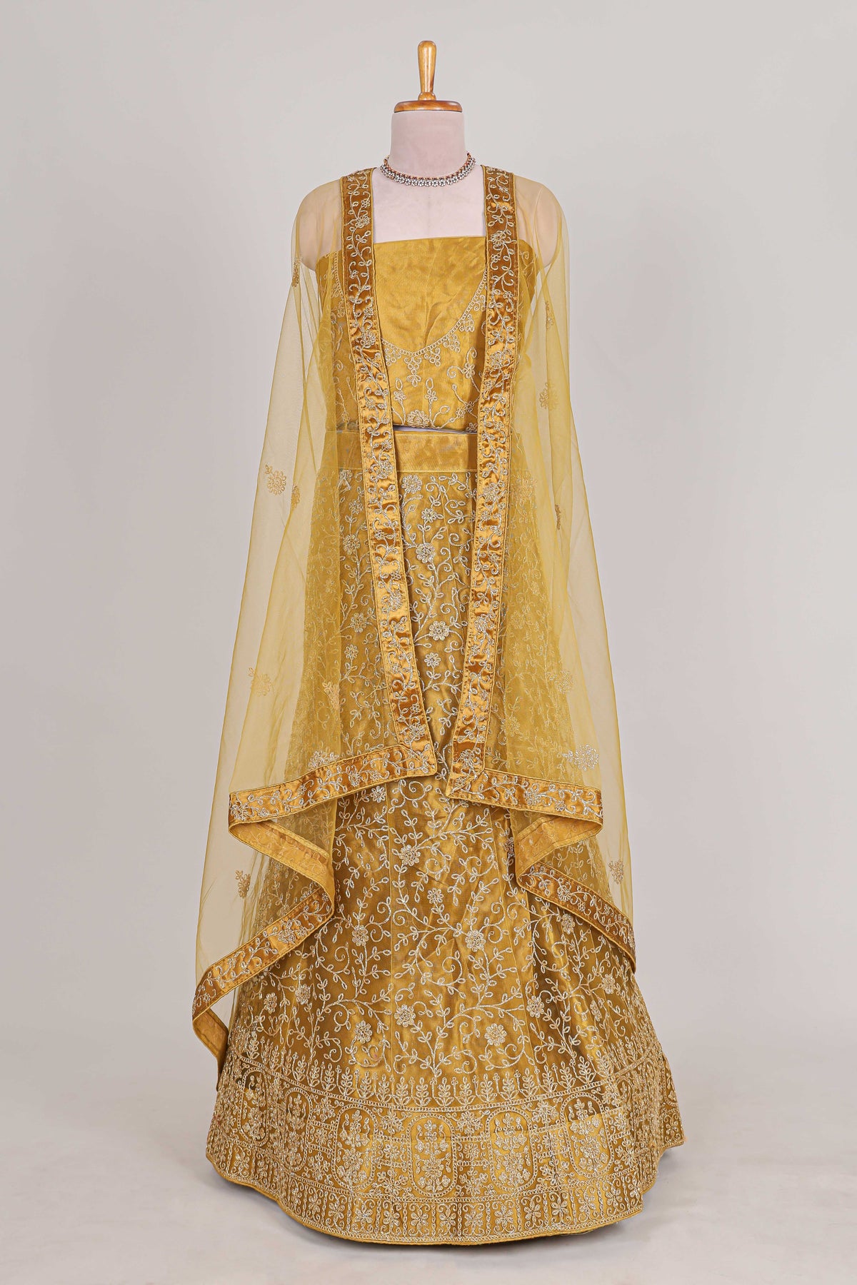 Sandle colour net lehenga featuring delicate embroidery with a borderless design paired with a matching self shawl