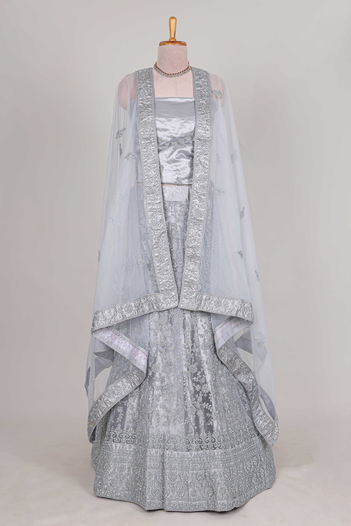 Silver colour net lehenga featuring delicate embroidery stone work with a borderless design paired with a matching self shawl