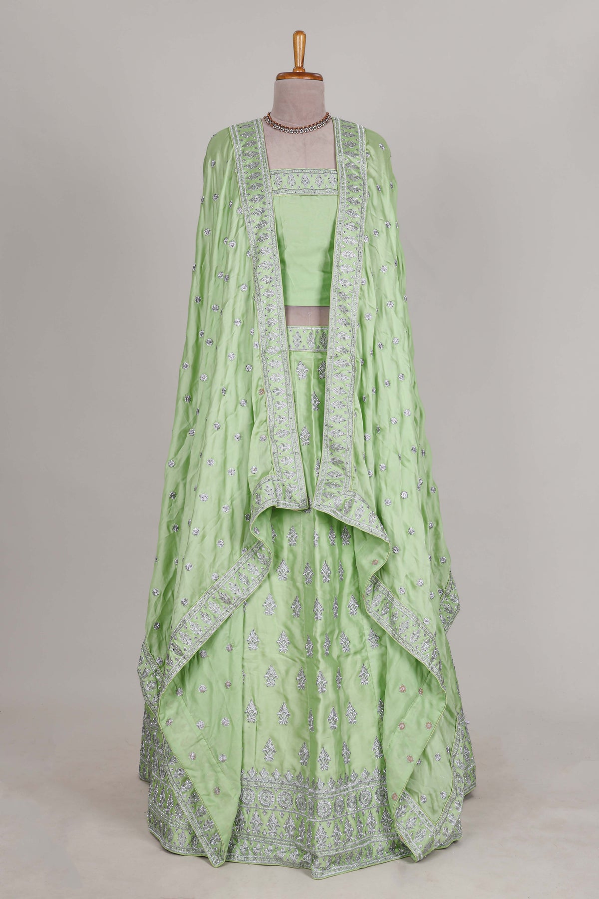 Powder green satin lehenga featuring delicate embroidery with a bordered design paired with a matching self shawl