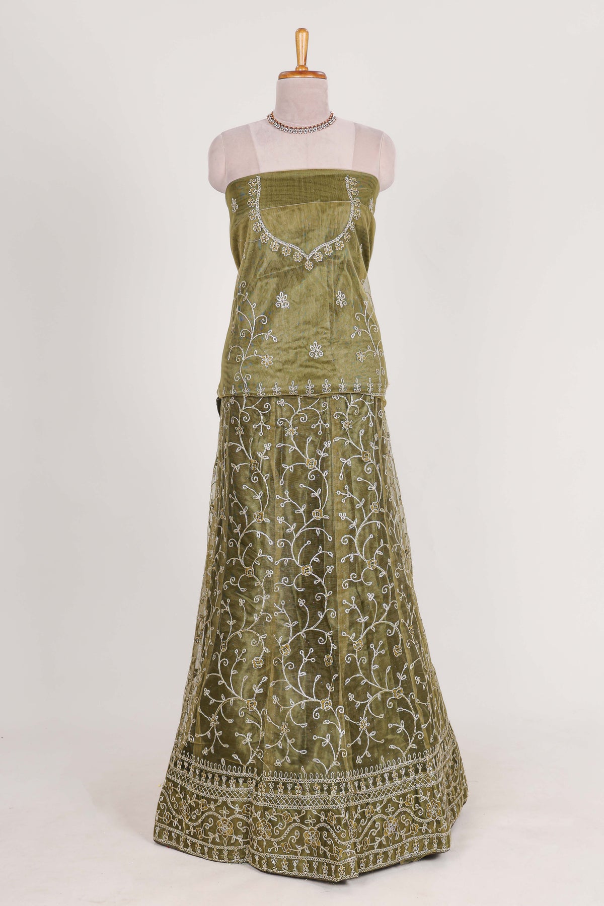 Olive Green net lehenga featuring delicate embroidery with a borderless design paired with a matching self shawl