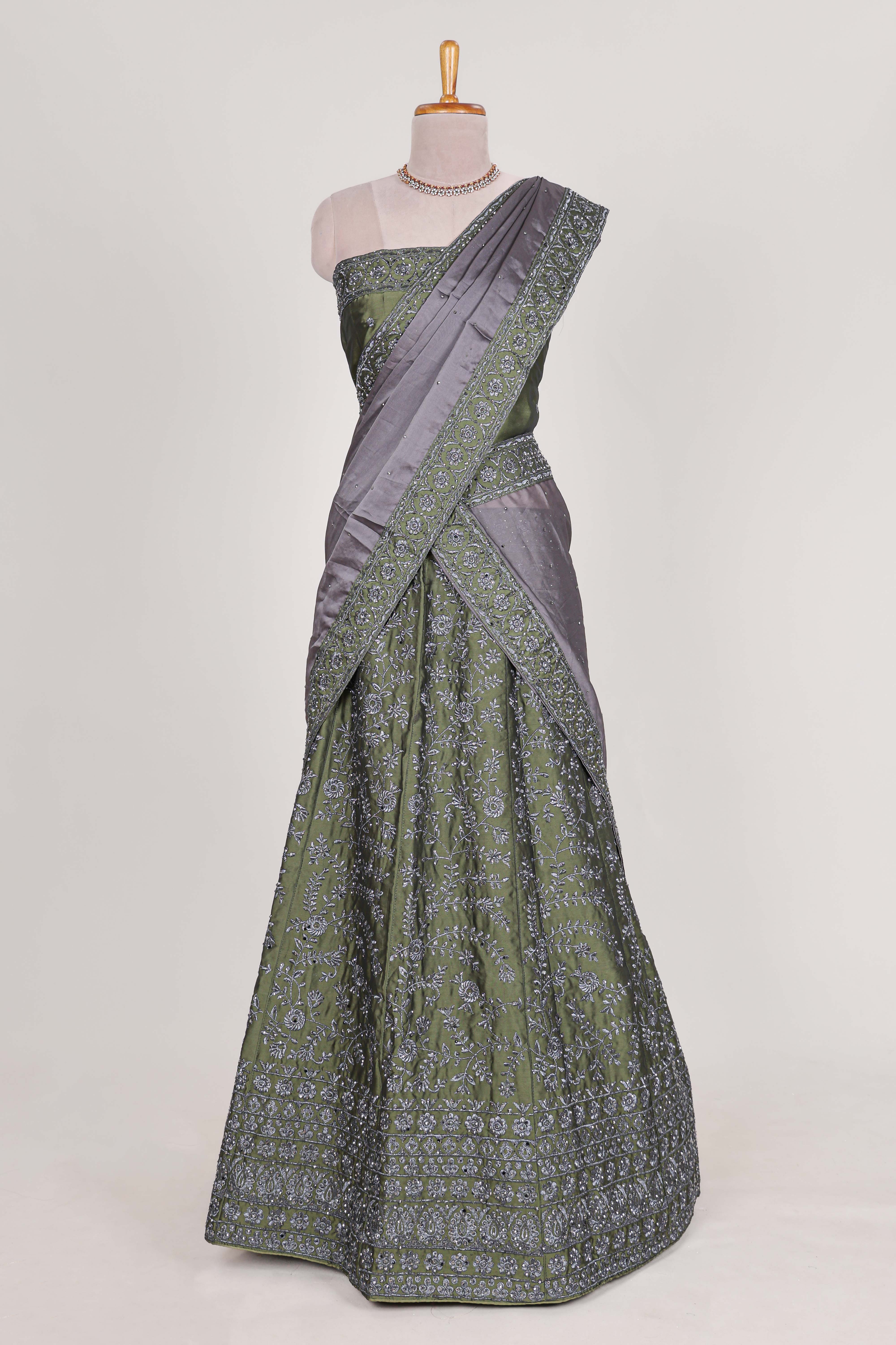 green satin lehenga featuring delicate embroidery with a bordered design paired with contrast shawl