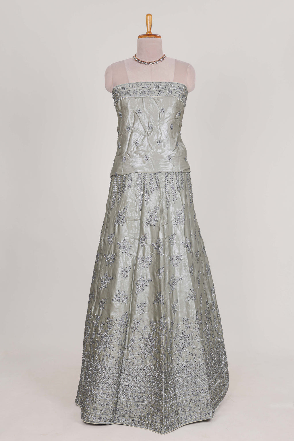 Silver satin lehenga featuring delicate embroidery with a bordered design paired with contrast shawl