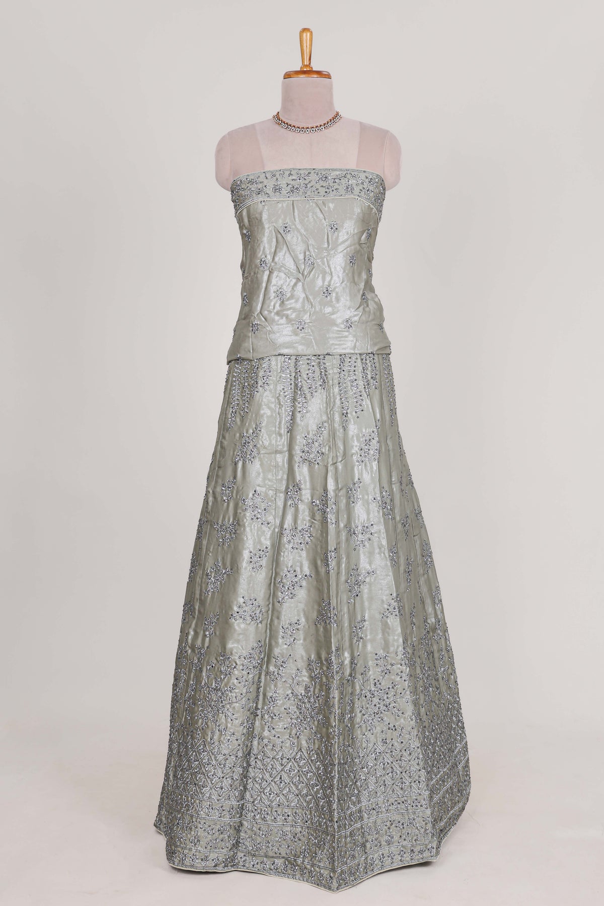 Silver satin lehenga featuring delicate embroidery with a bordered design paired with contrast shawl