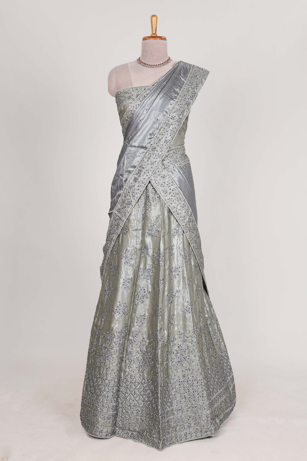 Silver satin lehenga featuring delicate embroidery with a bordered design paired with contrast shawl