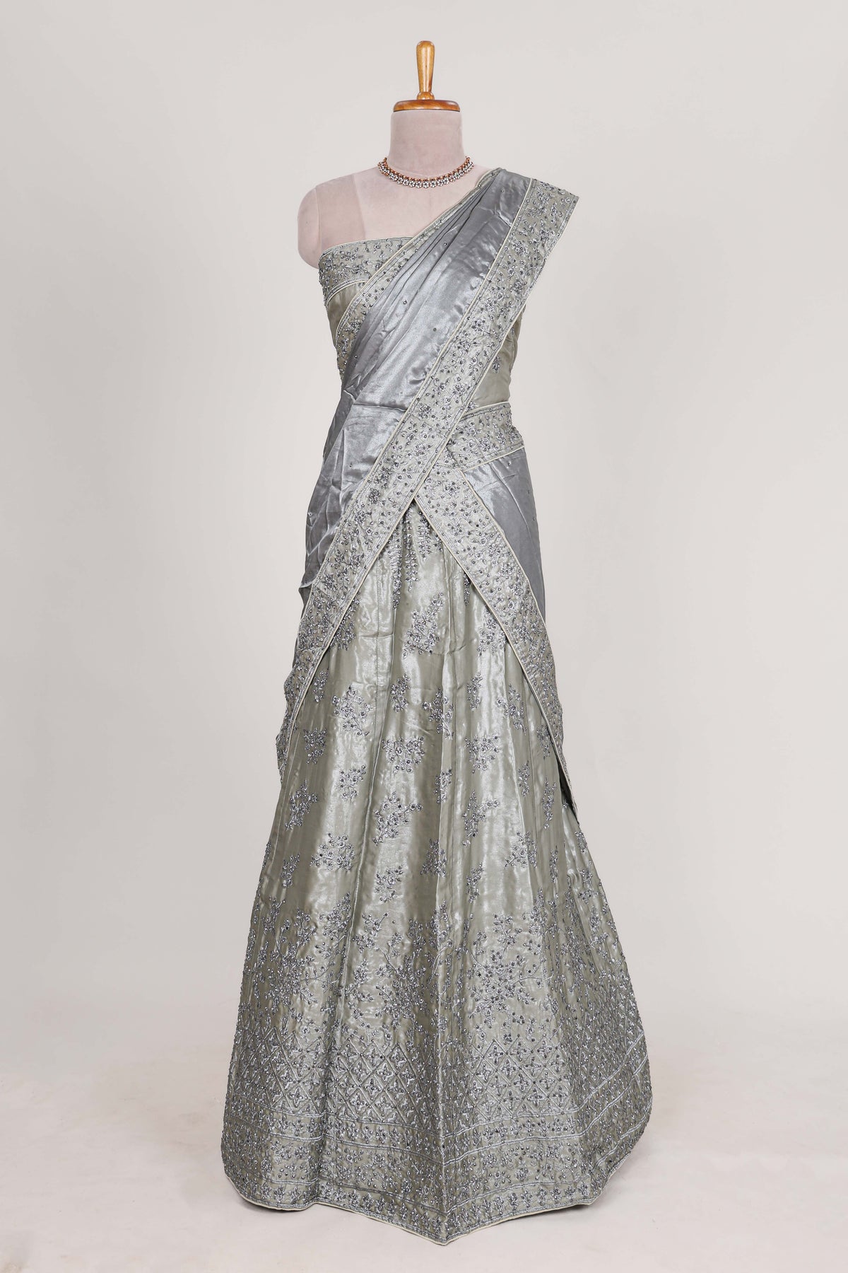 Silver satin lehenga featuring delicate embroidery with a bordered design paired with contrast shawl