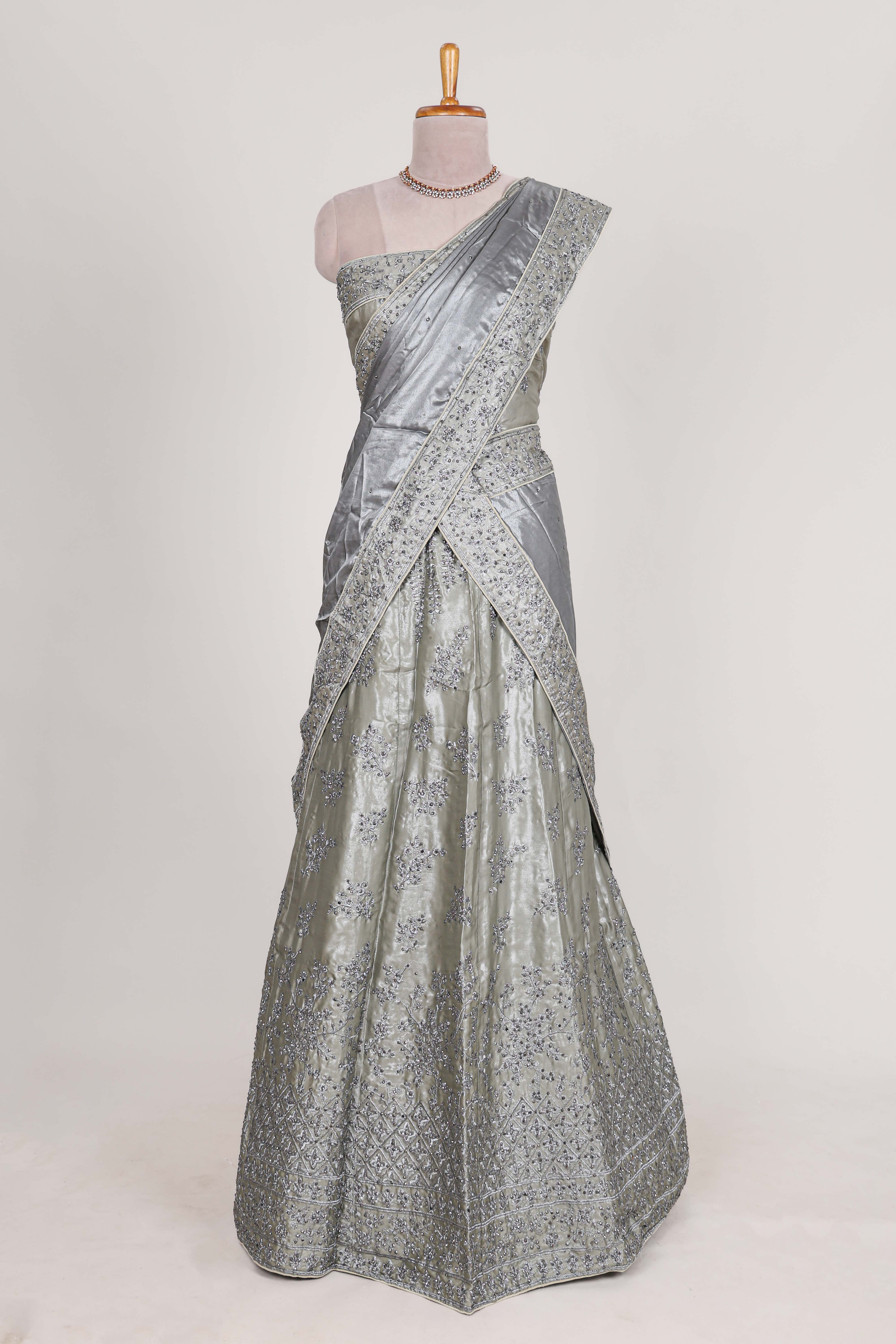 Silver satin lehenga featuring delicate embroidery with a bordered design paired with contrast shawl