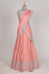 Peach satin lehenga featuring delicate embroidery with a bordered design paired with contrast shawl