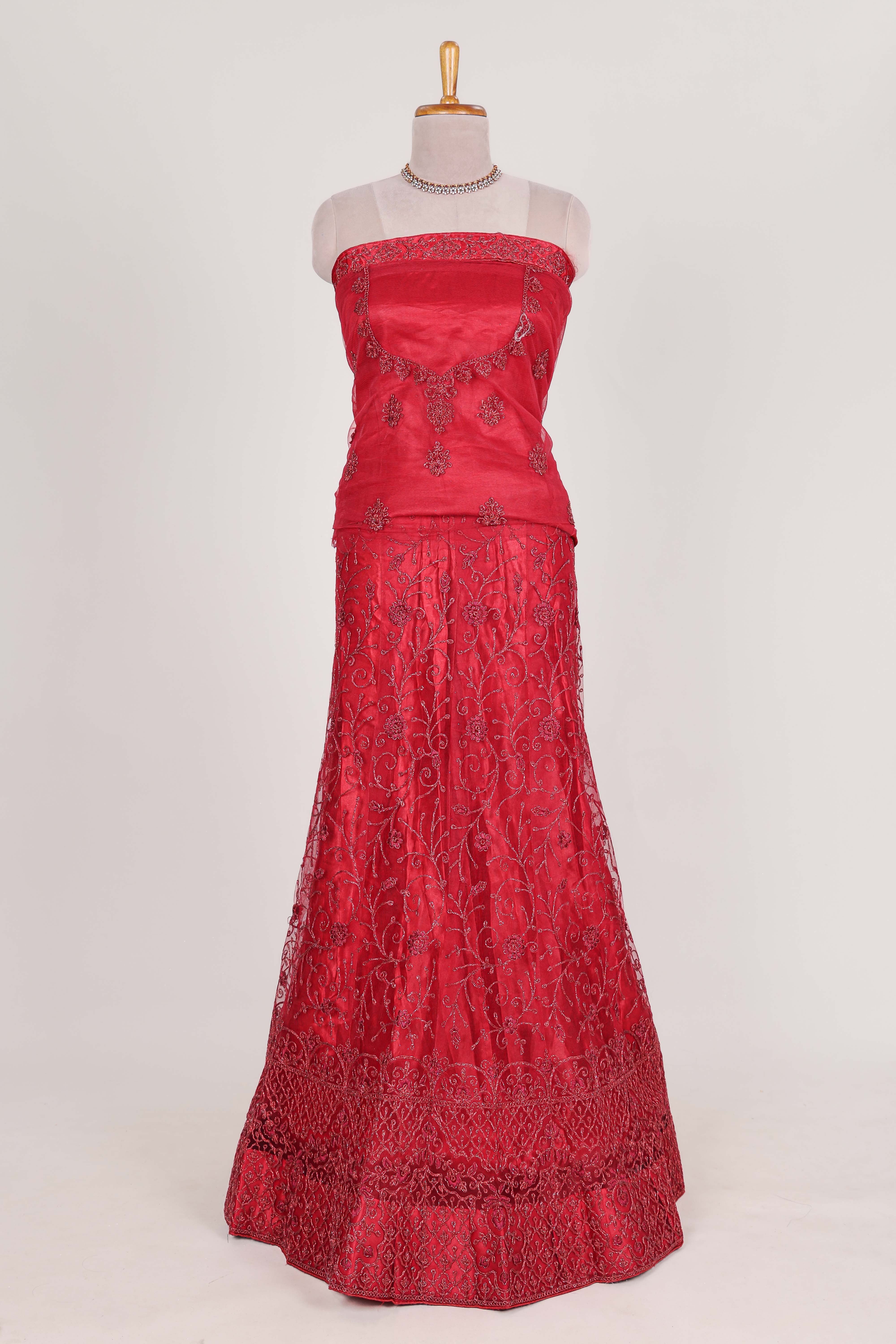 Bright red net lehenga intricate embroidery andpaired with a matching embroidered blouse