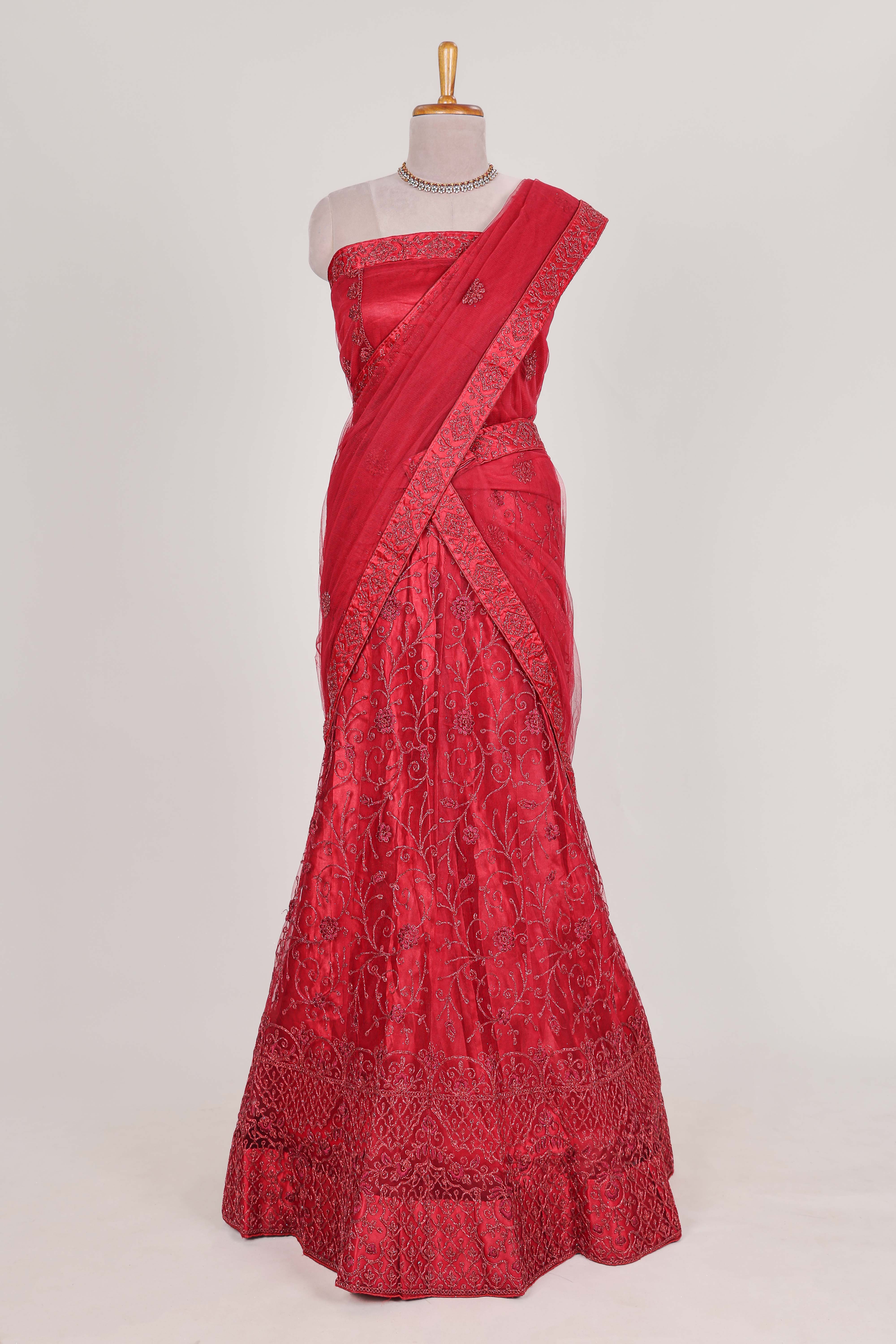 Bright red net lehenga intricate embroidery andpaired with a matching embroidered blouse