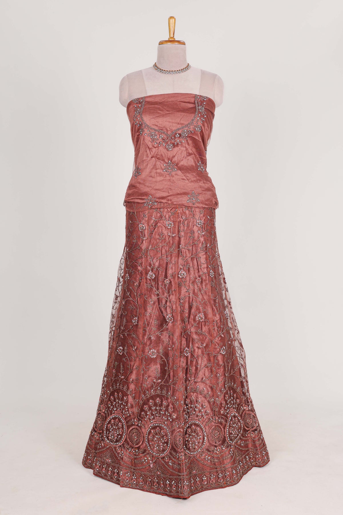 Brown net lehenga intricate embroidery and  paired with a matching embroidered blouse