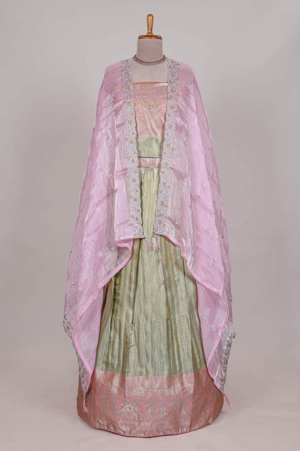 Pastel green tissue lehenga featuring elegant vertical line patterns with a beautiful contrast border Paired with a matching shawl