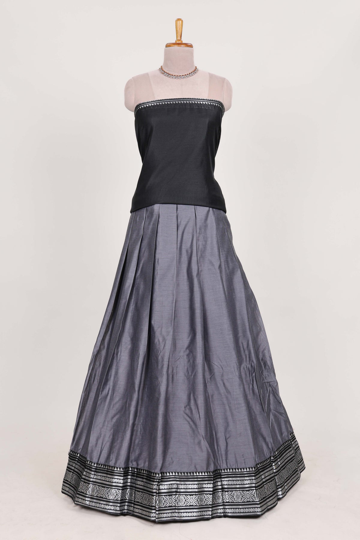 Grey silk cotton lehenga with a black shawl with a traditional silver zari woven border and contrast blouse
