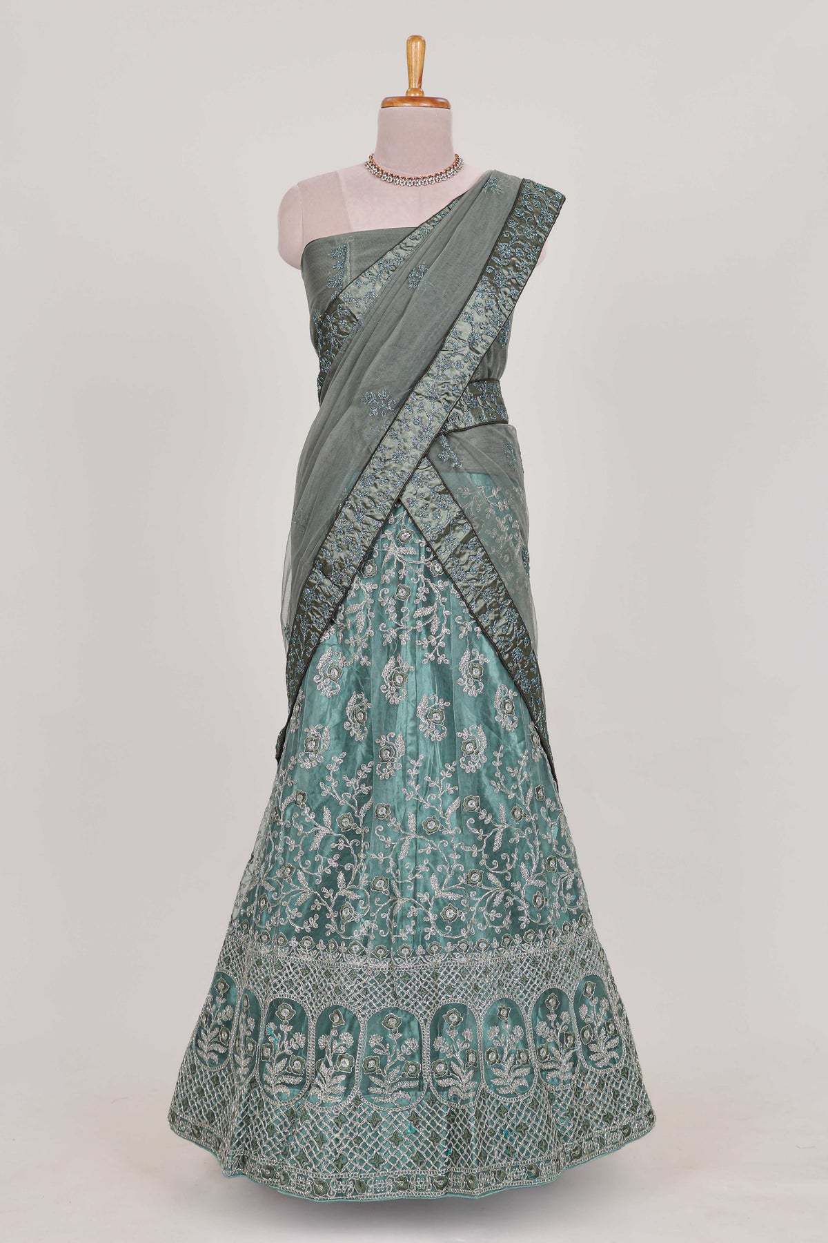 Pastel Sage Green Beautiful net lehenga with intricate embroidery stone work and contrast border paired with a contrast net shawl