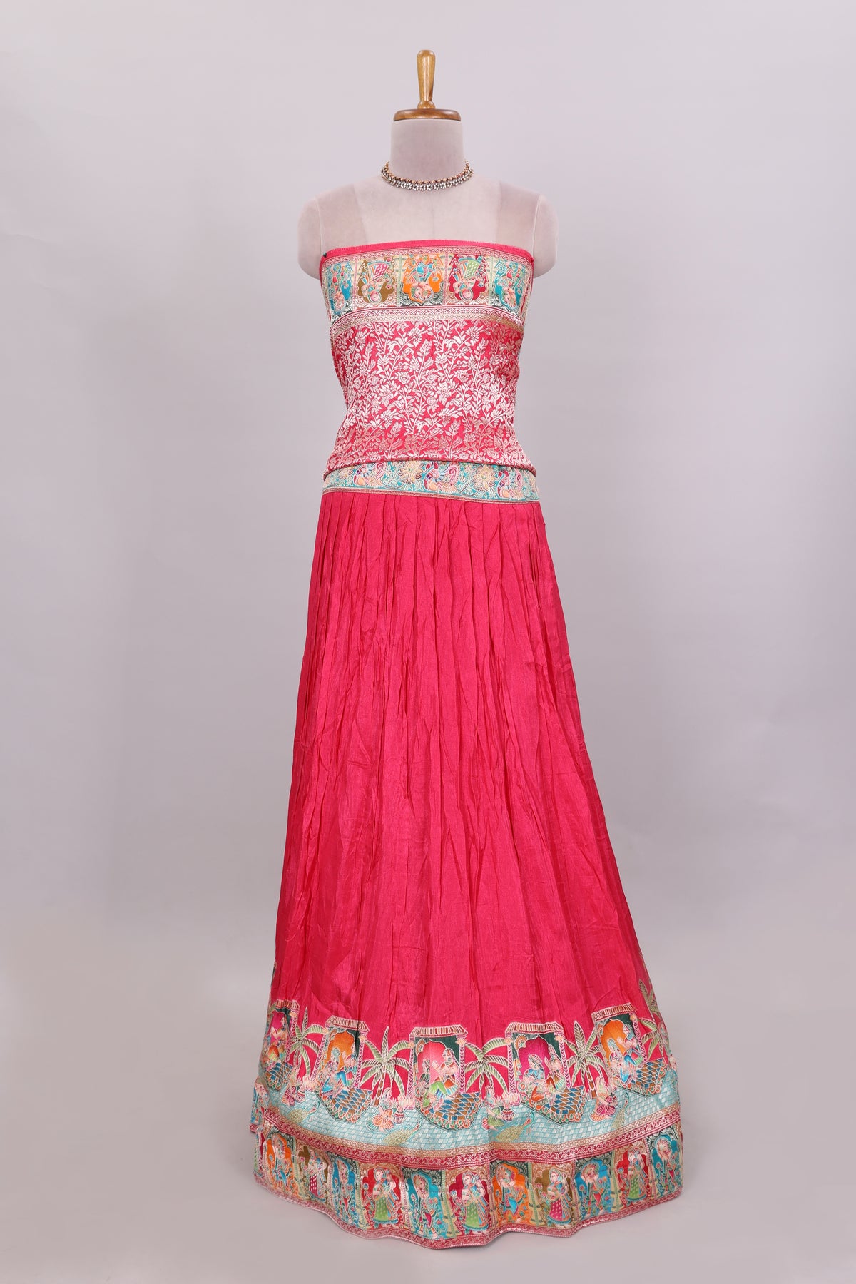 Rani pink plain lehenga featuring with human figure motifs with floral and ornamental detailing border Paired with a teal blue floral designed  shawl