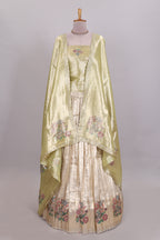 Gold shade zari designed lehanga with self floral motifs border and light green shade contrast blouse paired with plain shawl with few floral motifs