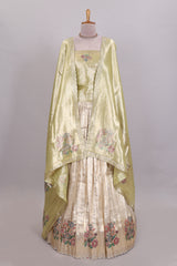 Gold shade zari designed lehanga with self floral motifs border and light green shade contrast blouse paired with plain shawl with few floral motifs