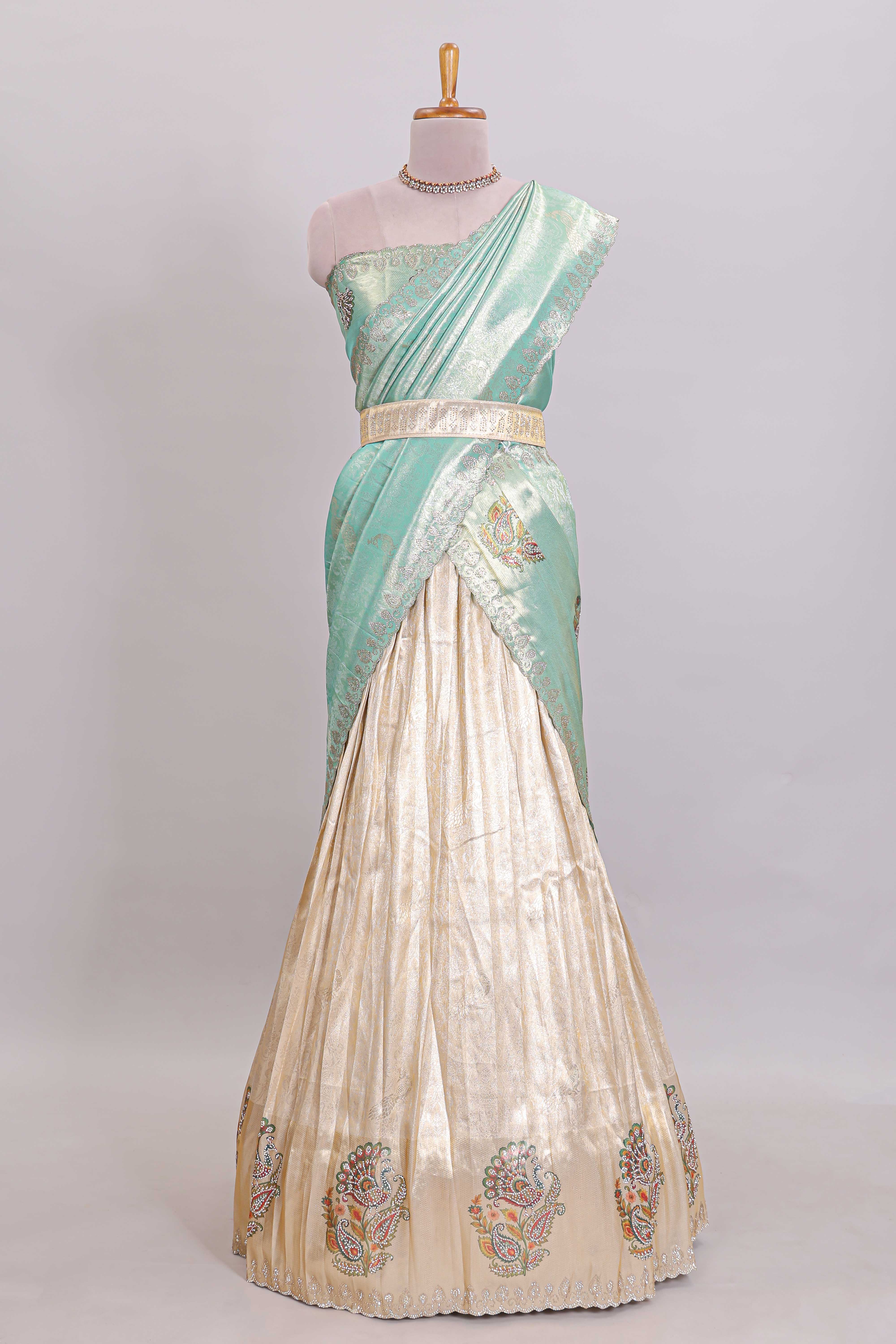 Off white tissue lehenga featuring intricate woven floral paisley motifs with a beautiful zari border Paired with a seafoam green shawl