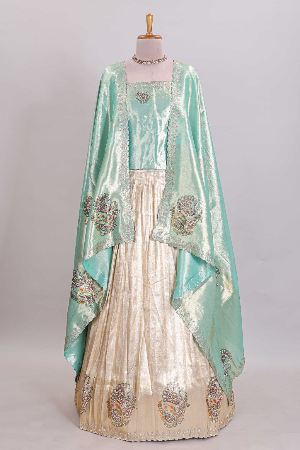 Off white tissue lehenga featuring intricate woven floral paisley motifs with a beautiful zari border Paired with a seafoam green shawl
