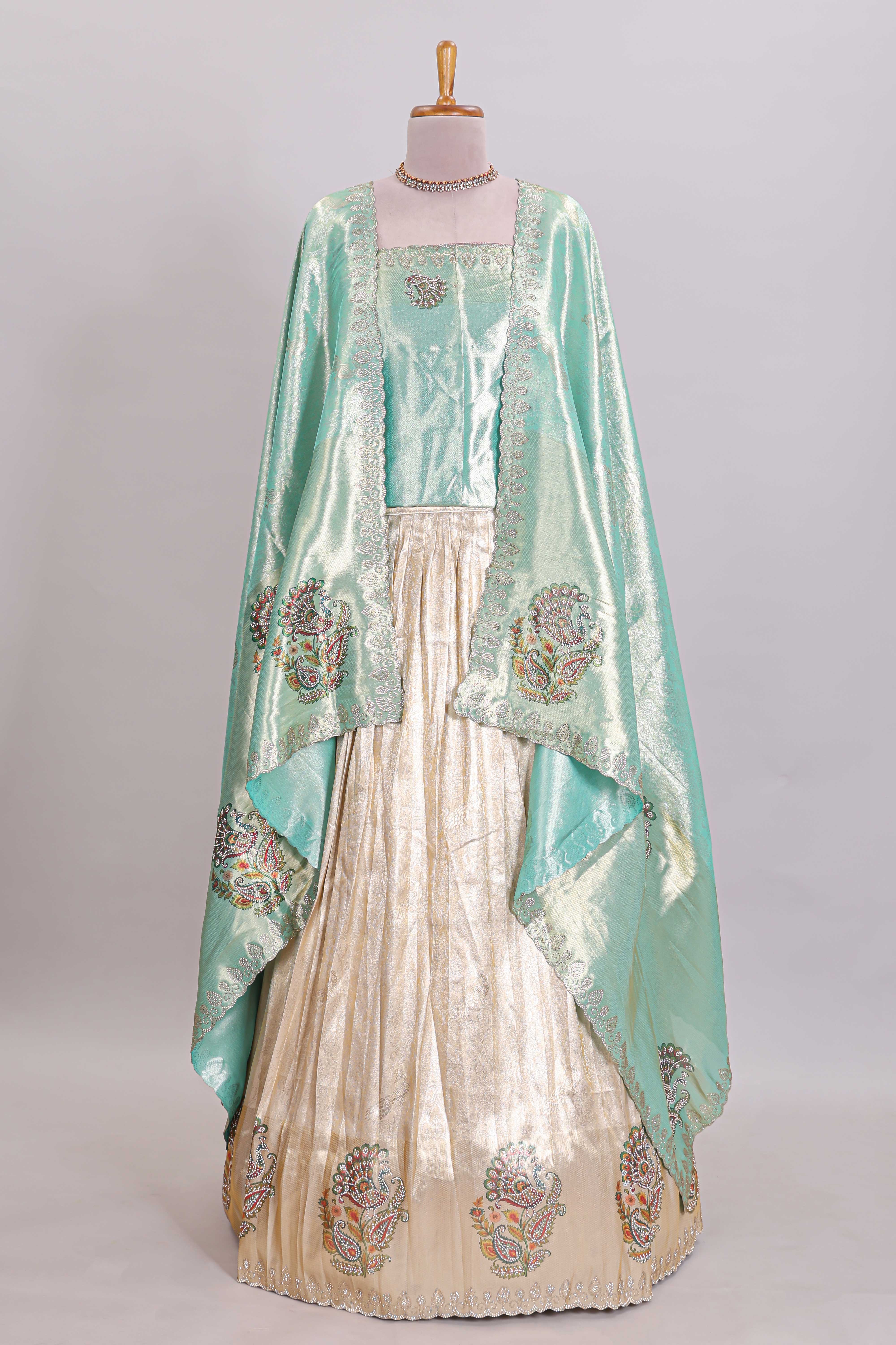 Off white tissue lehenga featuring intricate woven floral paisley motifs with a beautiful zari border Paired with a seafoam green shawl