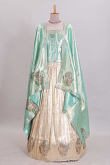 Off white plain lehanga featuring self floral butta design border and contrast teal green blouse beautifully embellished with a stone-work border paired with matching shawl