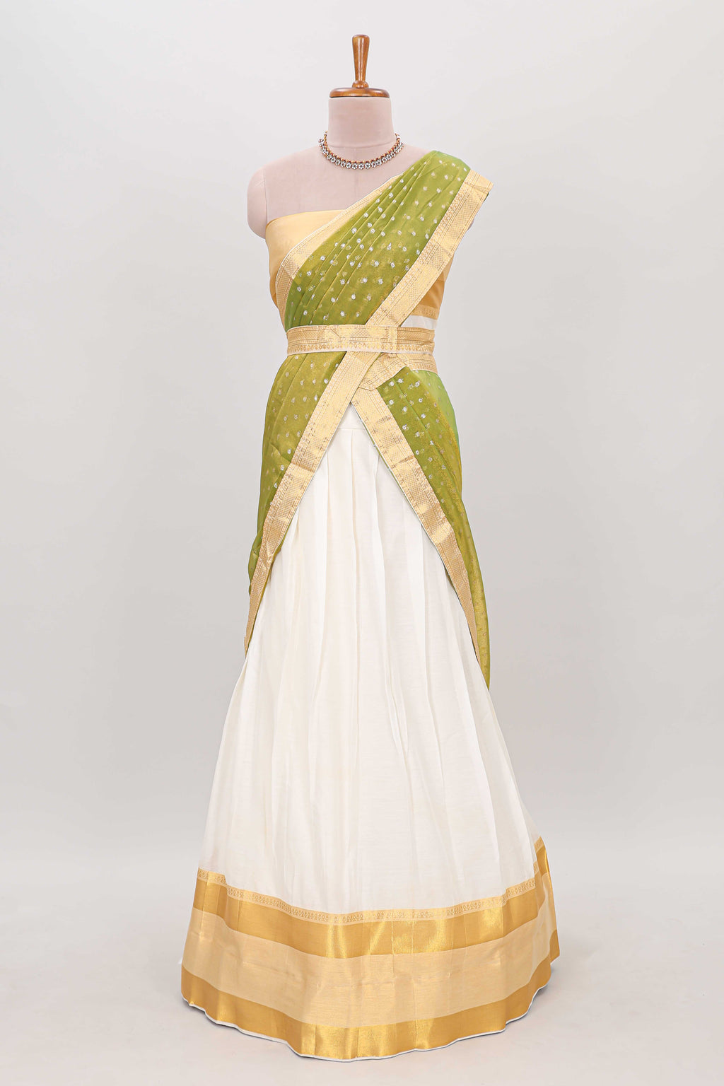 White plain lehanga featuring matching blouse paired with green stone work dhavani