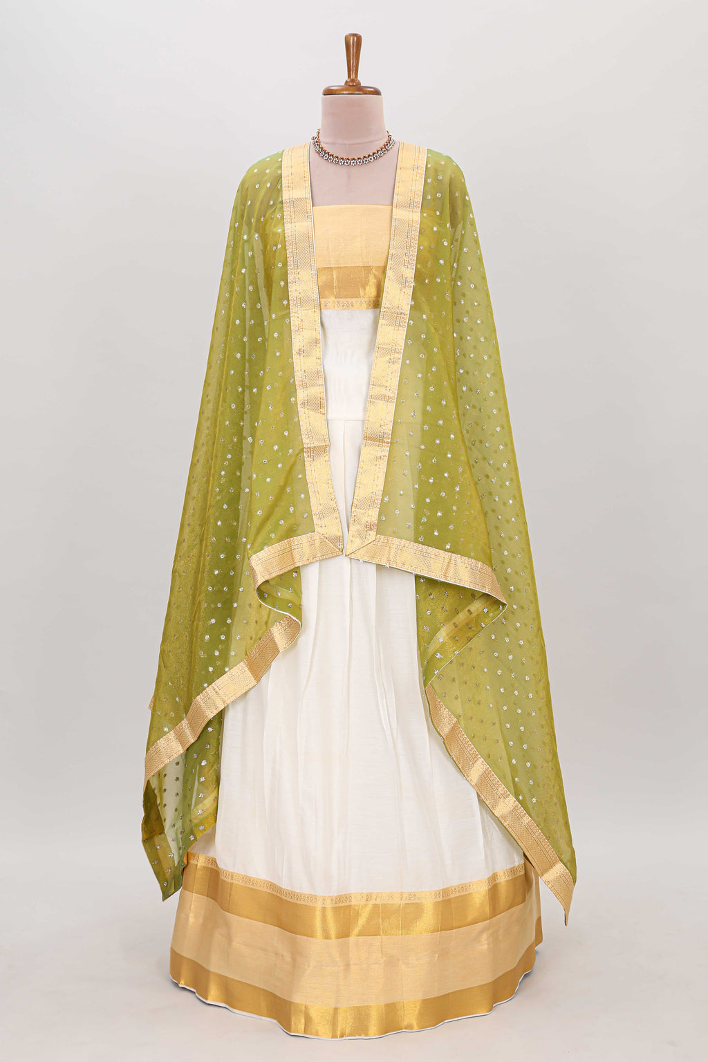 White plain lehanga featuring matching blouse paired with green stone work dhavani
