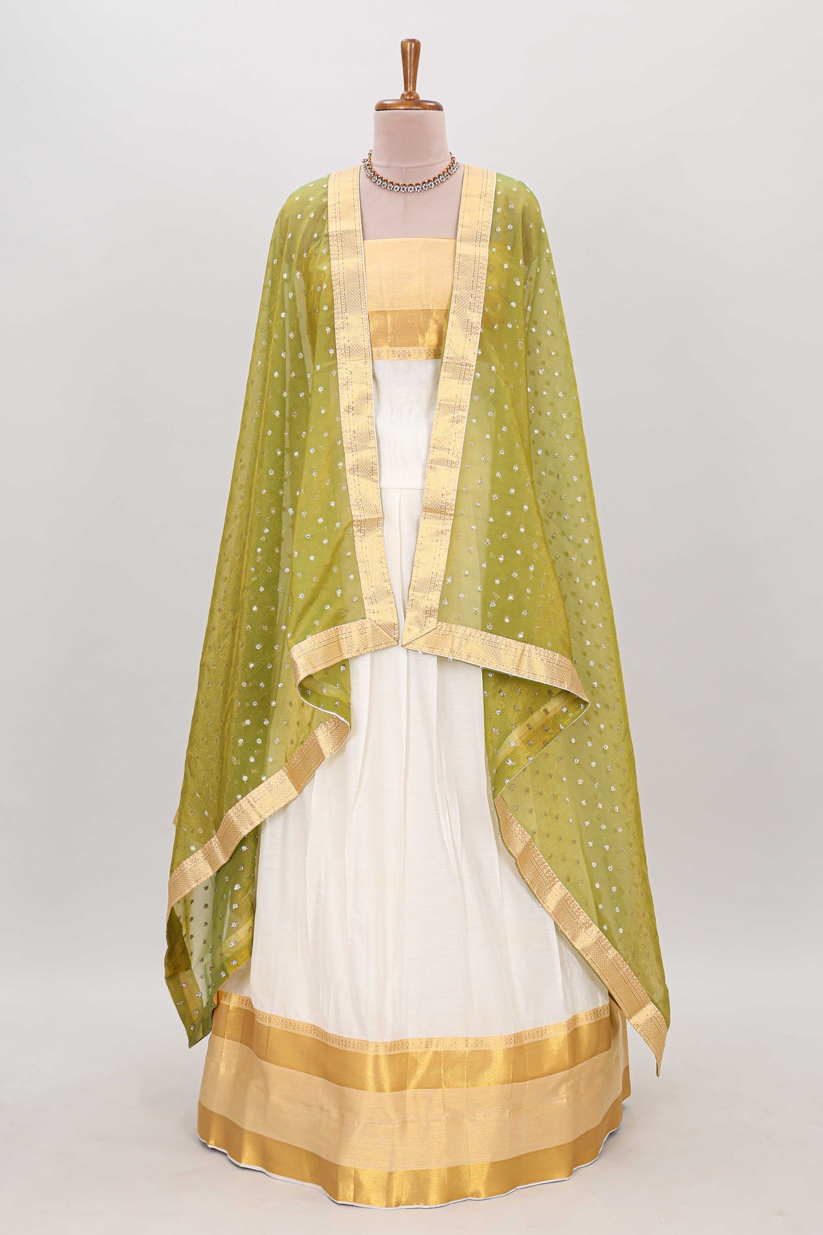 White plain lehanga featuring matching blouse paired with green stone work dhavani