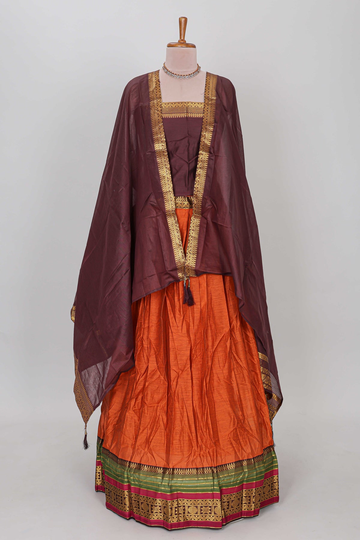 Orange shade plain lehanga featuring contrasting zari border and blouse paired with brown shawl